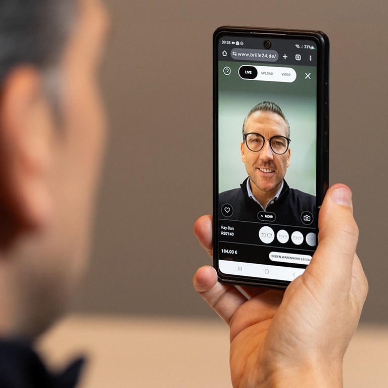 Ein Mann probiert eine Brille virtuell auf seinem Handy